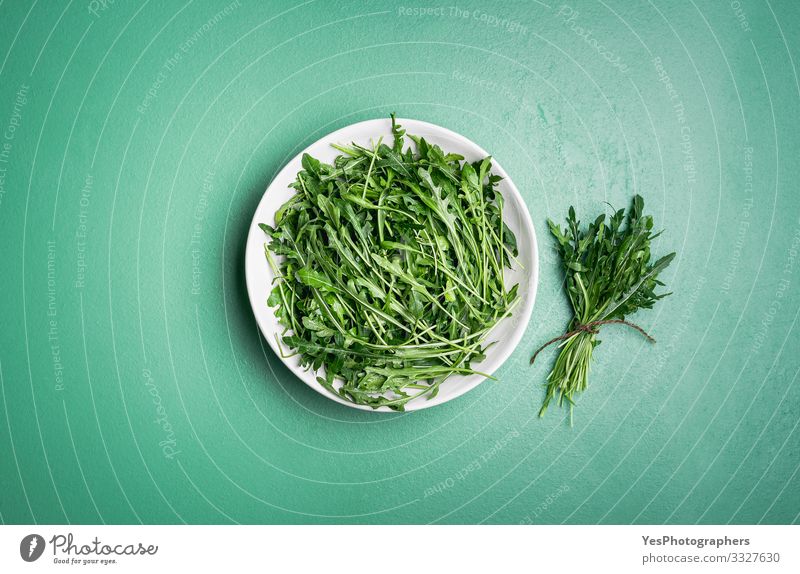 Arugula salad and arugula bundle on green table. Fresh herbs Vegetable Lettuce Salad Vegetarian diet Diet Healthy Eating Garden Gardening Plant Hip & trendy