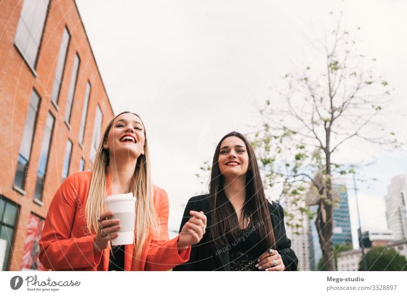 Two young friends walking together outdoors. Lifestyle Style Joy Happy Vacation & Travel To talk Human being Feminine Woman Adults Friendship Town Street