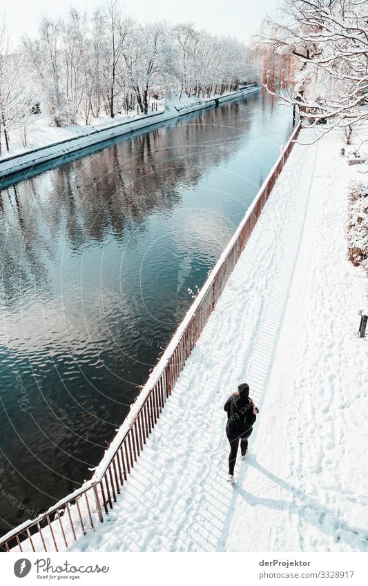 Jogging person in winter by the canal in Kreuzberg metropolis Freedom City Berlin center Panorama (View) Sunbeam urban Beautiful weather City life Sunlight