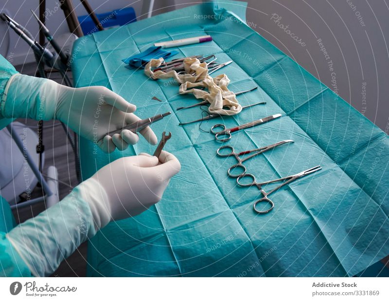 Anonymous doctor talking surgical instruments during operation in hospital tool equipment uniform gloves sterile preparing surgery nurse medicine patient