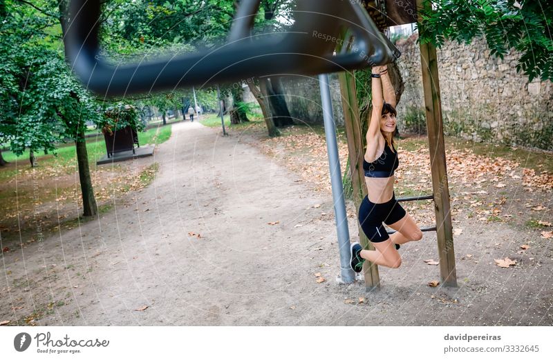 Woman doing monkey exercises on rings Lifestyle Body Sports Human being Adults Tree Park Lanes & trails Sneakers Fitness Smiling Thin Strong Determination