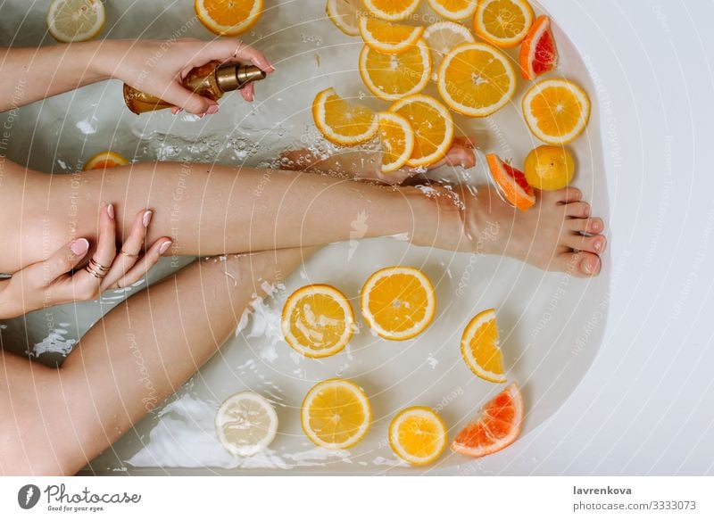 Woman's hand and legs in a bath filled with water Aromatic Swimming & Bathing Bathroom Bathtub Beauty Photography Bomb Bubble care Lemon Citrus fruits Clean