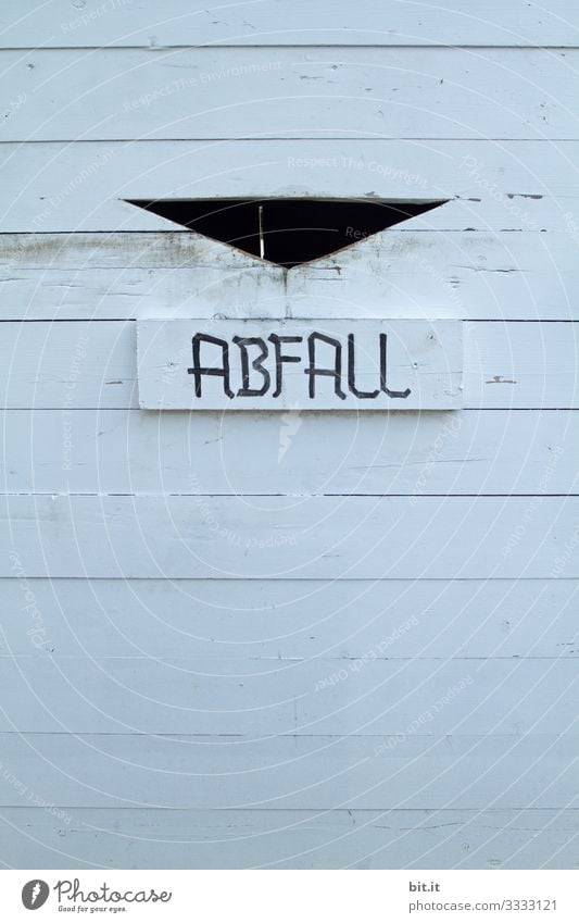 Waste lettering on a white wooden waste container for waste separation, sustainability and climate change, in the garden. Trash Climate change Dirty Environment