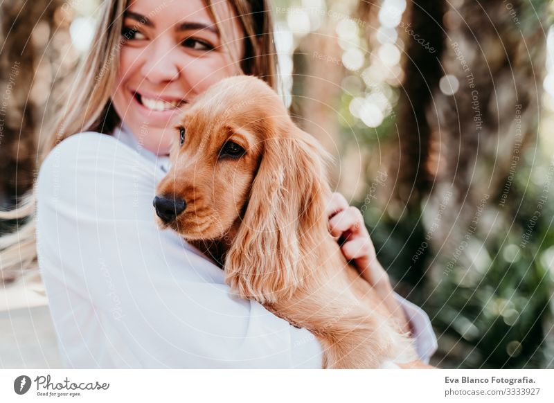 young woman and her cute puppy of cocker spaniel outdoors in a park Woman Dog Pet Park Sunbeam Exterior shot Love Embrace Smiling Rear view Kissing Breed