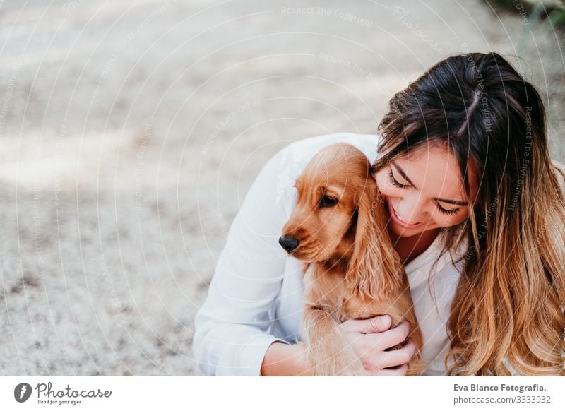 young woman and her cute puppy of cocker spaniel outdoors in a park Woman Dog Pet Park Sunbeam Exterior shot Love Embrace Smiling Rear view Kissing Breed