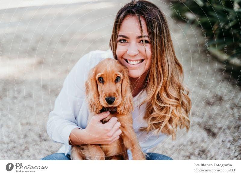 young woman and her cute puppy of cocker spaniel outdoors in a park Woman Dog Pet Park Sunbeam Exterior shot Love Embrace Smiling Rear view Kissing Breed