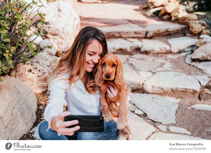 young woman taking a selfie with her cute puppy of cocker spaniel outdoors Selfie Cellphone Technology Woman Cocker Spaniel Dog Pet Park Sunbeam Exterior shot