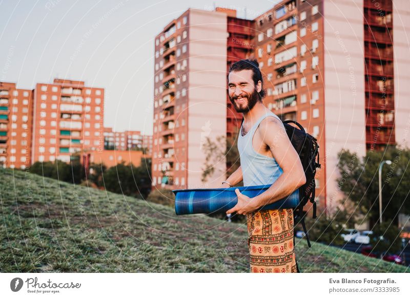 young man in a park ready to practice yoga sport. city background. healthy lifestyle Concentrate Position Human being Youth (Young adults) Body Park Man