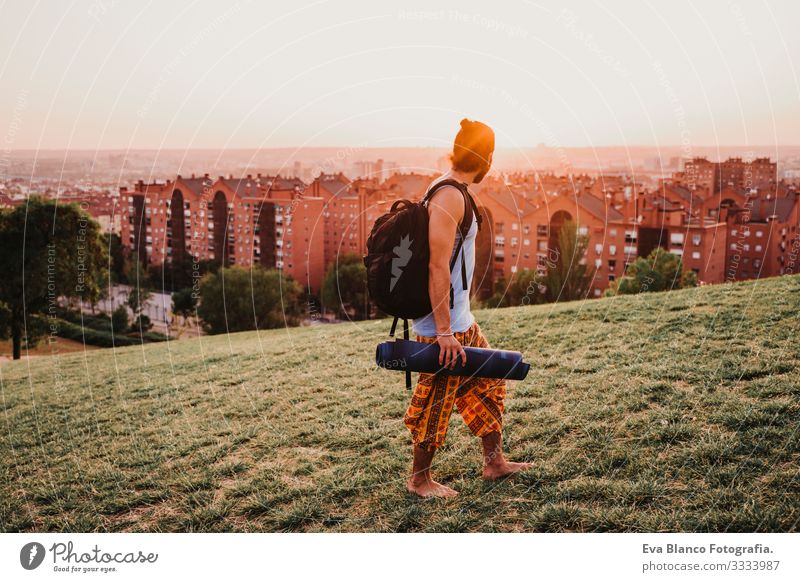 young man in a park ready to practice yoga sport. city background. healthy lifestyle Concentrate Position Human being Youth (Young adults) Body Park Man