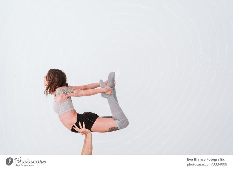 young couple Couple practicing acro yoga in white studio or gym. Healthy lifestyle Yoga Sports Gymnasium indoor Man Power Human being human relationships