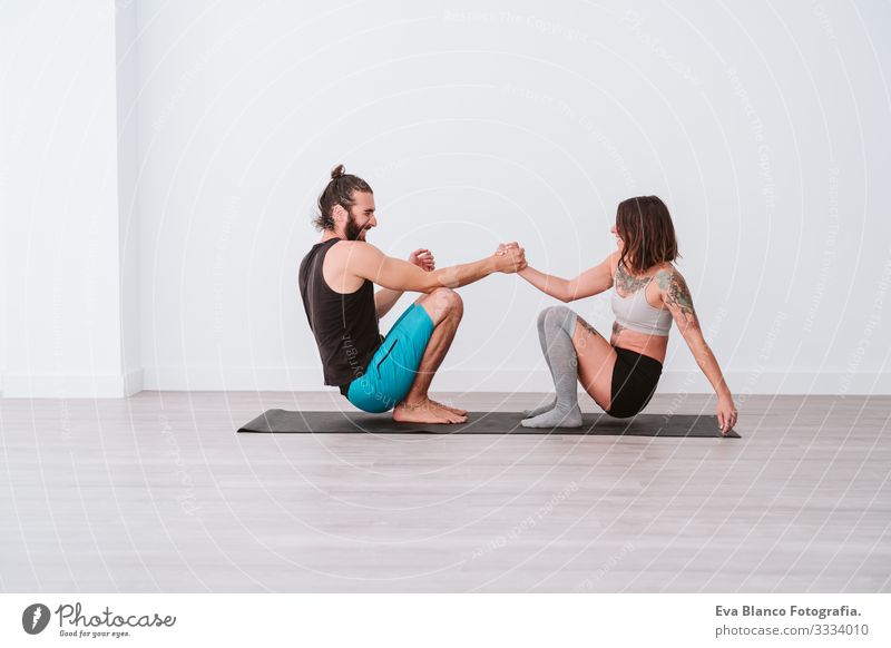 young couple Couple practicing acro yoga in white studio or gym. Healthy lifestyle Yoga Sports Gymnasium indoor Man Power Human being human relationships