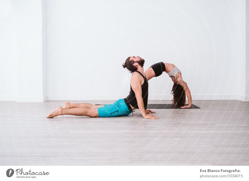 young couple Couple practicing acro yoga in white studio or gym. Healthy lifestyle Yoga Sports Gymnasium indoor Man Power Human being human relationships