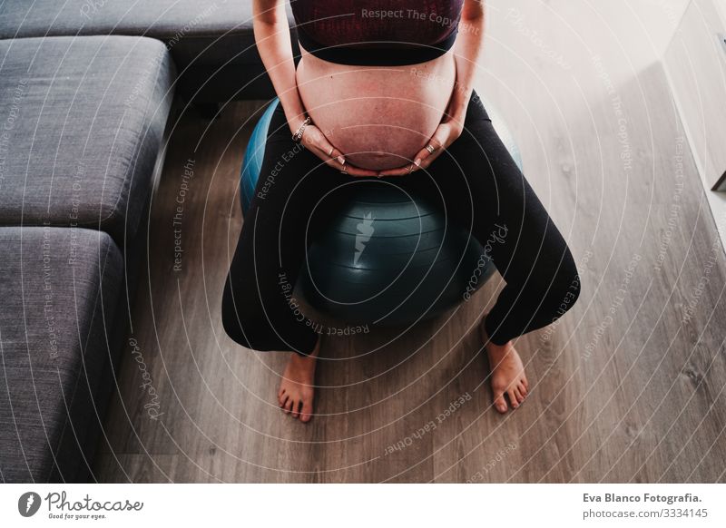 young pregnant woman at home sitting on pilates ball, healthy lifestyle Pregnant Woman Yoga Home Sports Healthy Lifestyle Youth (Young adults) Caucasian