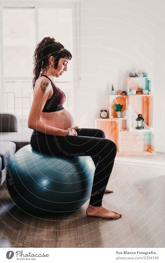 young pregnant woman at home sitting on pilates ball, healthy lifestyle Pregnant Woman Yoga Home Sports Healthy Lifestyle Youth (Young adults) Caucasian