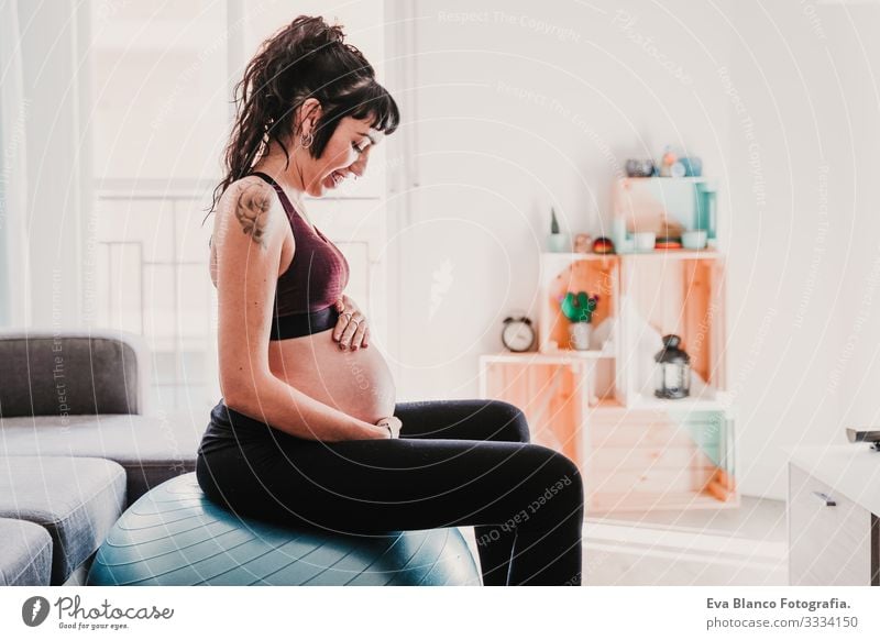 young pregnant woman at home sitting on pilates ball, healthy lifestyle Pregnant Woman Yoga Home Sports Healthy Lifestyle Youth (Young adults) Caucasian