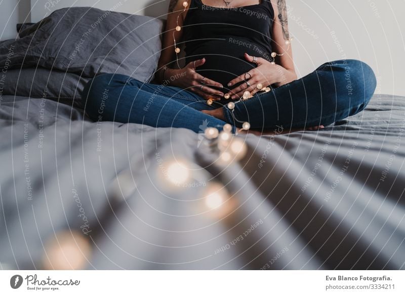 young pregnant woman at home holding a garland of lights Pregnant Woman Home Paper chain Light Christmas & Advent Smiling Happy Portrait photograph