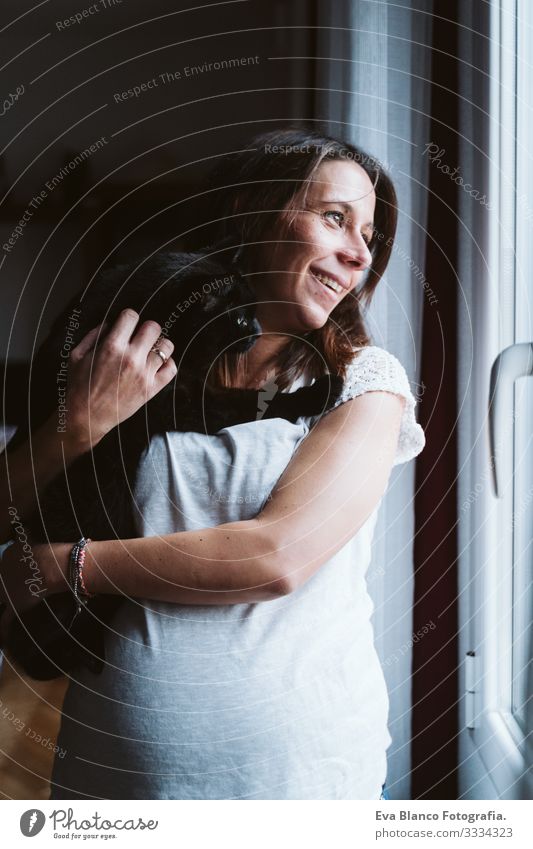 young pregnant woman at home holding a black cat on shoulder Pregnant Woman Youth (Young adults) pregnancy Home maternity Life Showing one's bellybutton