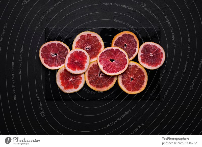 Grapefruit slices on a black table. Sliced fresh citrus fruit Food Fruit Breakfast Healthy Eating Fresh above view antioxidant fruit black background