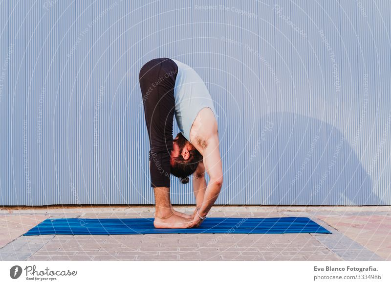 man in the city practicing yoga sport. blue background. healthy lifestyle Yoga Man Sports Healthy Exterior shot City Blue background Muscular