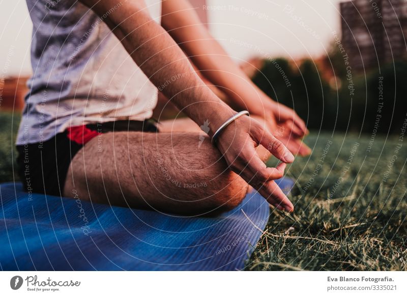 young man in a park practicing yoga sport. city background. healthy lifestyle. Man Youth (Young adults) Yoga Sports City Park Sunset Lifestyle Healthy Mat