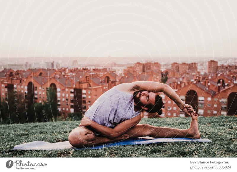 young man in a park practicing yoga sport. city background. healthy lifestyle. Man Youth (Young adults) Yoga Sports City Park Sunset Lifestyle Healthy Mat