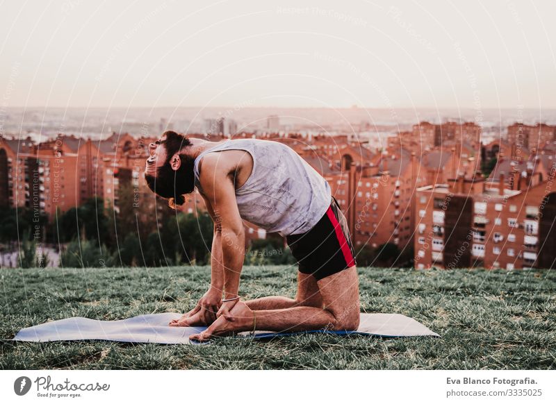 young man in a park practicing yoga sport. city background. healthy lifestyle. Man Youth (Young adults) Yoga Sports City Park Sunset Lifestyle Healthy Mat