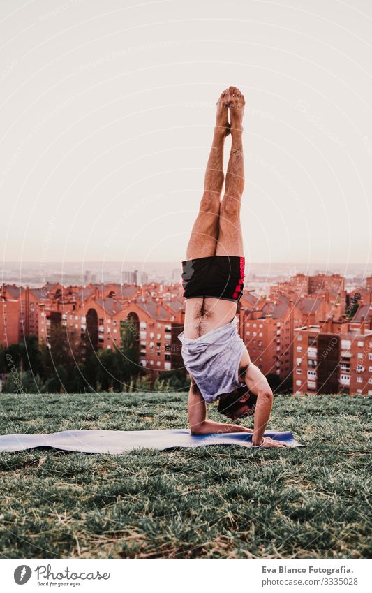 young man in a park practicing yoga sport. city background. healthy lifestyle. Man Youth (Young adults) Yoga Sports City Park Sunset Lifestyle Healthy Mat