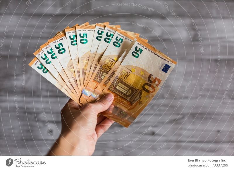 woman hand holding cash isolated on grey wood background. Euro fifty bills. European Money wealth Hold payment Financial Financial institution Business