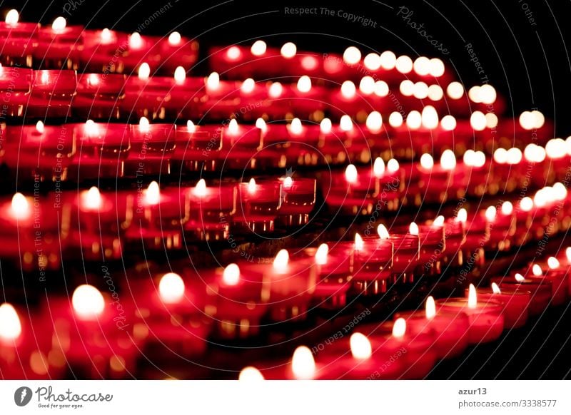 Group of red candles in church for faith resurrection prayer hope sacrifice silence grief love peace soul religion candlelight fire flames obituary obsequies