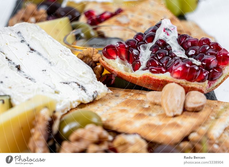 Food Platter With Truffle Cheese, Duck Breast, Brie Cheese, Pecan Nuts, Pomegranate Seeds, Grapes, Almonds, Honey, Olives and Crackers crackers almonds