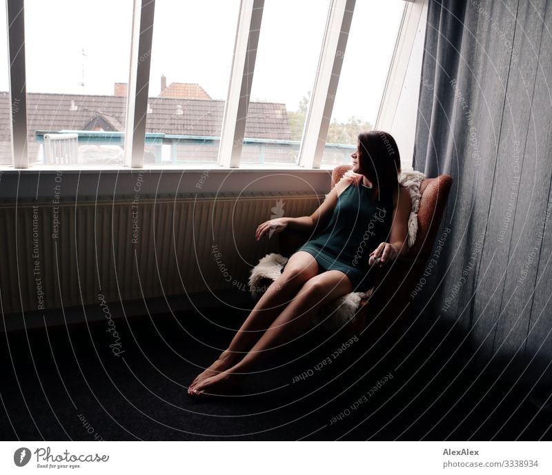 Portrait of a young tall woman in an armchair in front of a window Lifestyle Style already Harmonious Living or residing Flat (apartment) Living room