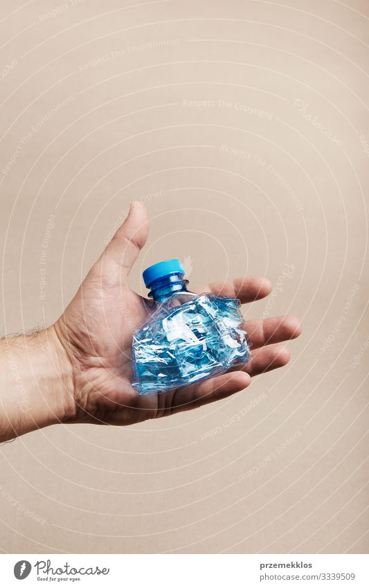 Male hand holding squashed plastic bottle Bottle Save Man Adults Hand Environment Container Plastic Blue Environmental pollution Trash garbage recycle Recycling