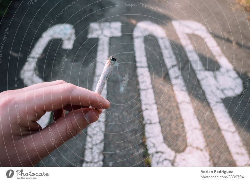 Hand holding a cigarette with a stop message in the background Health care Illness Human being Fingers Protection Death Horror Dangerous Stress addiction