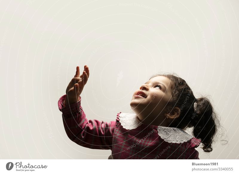 Happy little girl with fringe hairstyle on the side in the lower part of the picture with view to the frame Middle parting hairstyle Site pony two years care