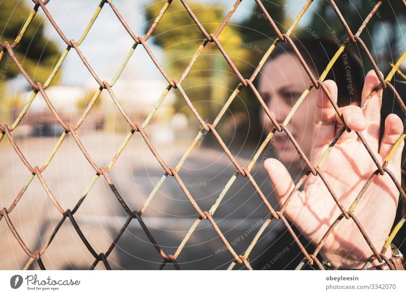 woman stading beohind a faence feeling trapped and alone Beautiful Woman Adults Environment Think Loneliness Considerate tranquil outdoor scene early morning