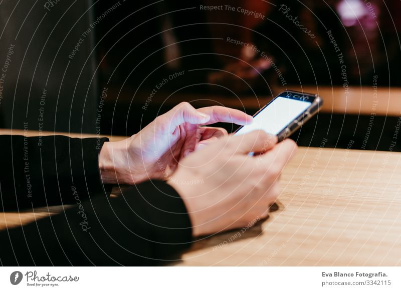 close up view of young woman using mobile phone in a cafe or restaurant indoors. Unrecognizable person lifestyles Woman Cellphone Interior shot Restaurant Café