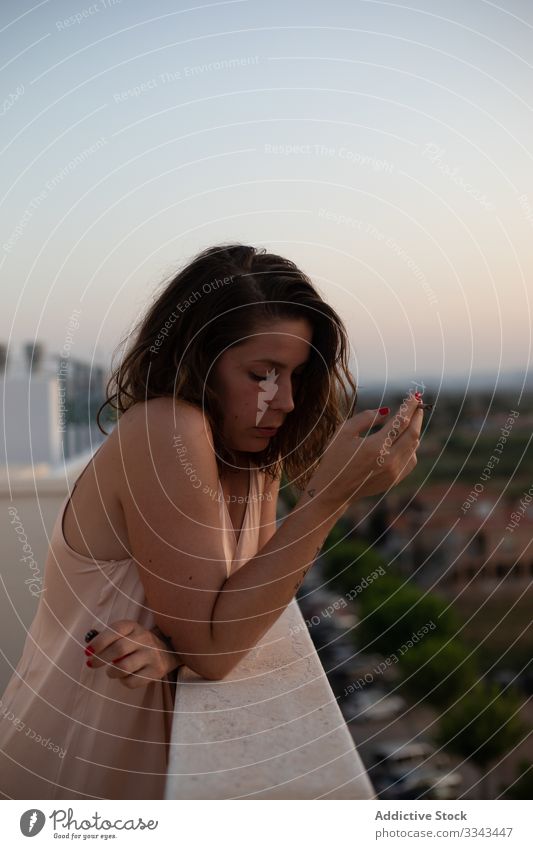 Sad woman standing at balcony anxious complicated concerned crisis depression joint drama smoke blunt weed cigarette marijuana exhausted female failure casual