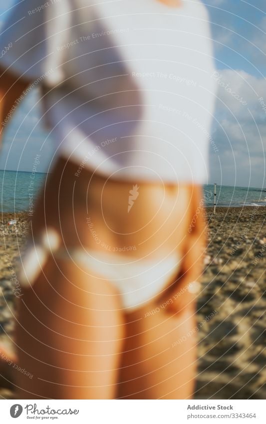 Unrecognizable lady resting on empty seaside woman relax seashore summer sand beach coast ocean water sky blue heaven white t shirt bikini vacation travel