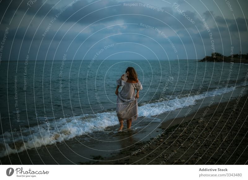 Female tourist seaside woman beach waves barefoot seashore sky heaven dusk clouds female lady walking coastline empty lonely blue dress beautiful vacation water