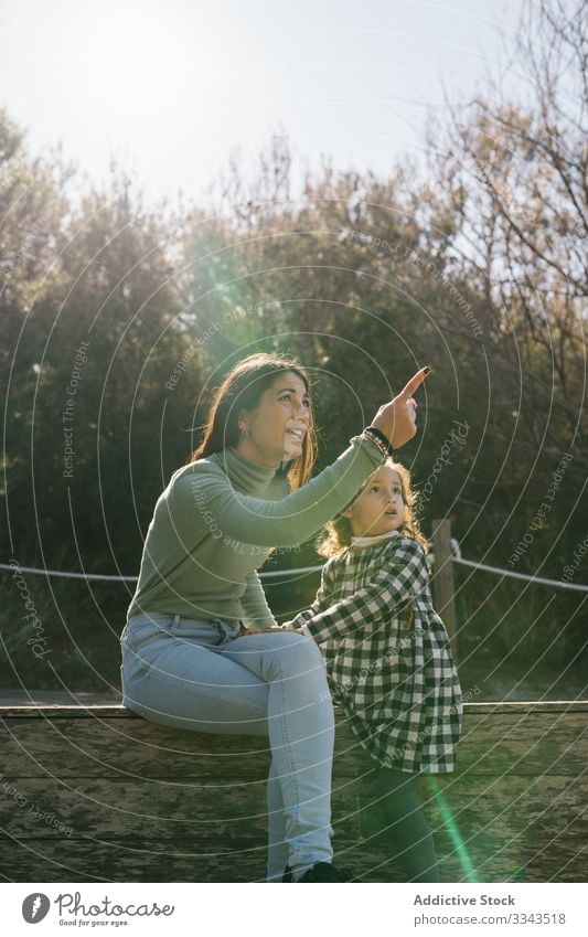 Mother and daughter having fun on nature mother child kiss hug playing smiling girl cuddle kid affection together weekend rest childhood countryside ethnic day