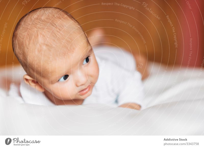 Lovely newborn baby lying on bed home infant lovely adorable child calm small cute kid sweet portrait pajama casual innocent peaceful serious rest house day