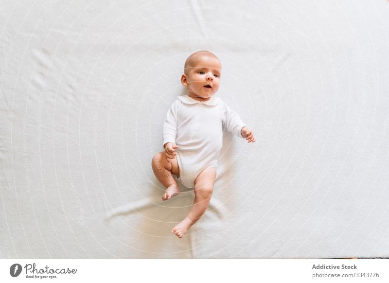 Adorable newborn baby lying on bed home infant adorable child calm small cute kid sweet pajama casual innocent peaceful open mouth rest house day comfortable