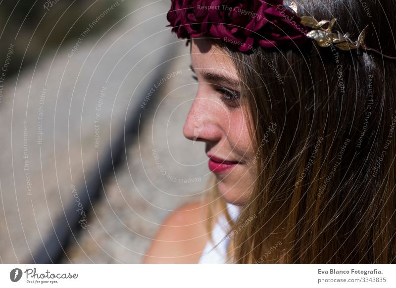 Profile face Portrait Beautiful young woman with a red roses wreath on her head. Red lips. Outdoors. Sunny. Railway. Lifestyle Freedom Beauty Photography