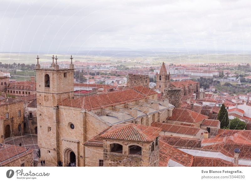 Aerial views of the beautiful city of Caceres, Spain. Stone fortress town. Cathedral in front. Cloudy sky Catholicism historical Statue medieval Church Deserted