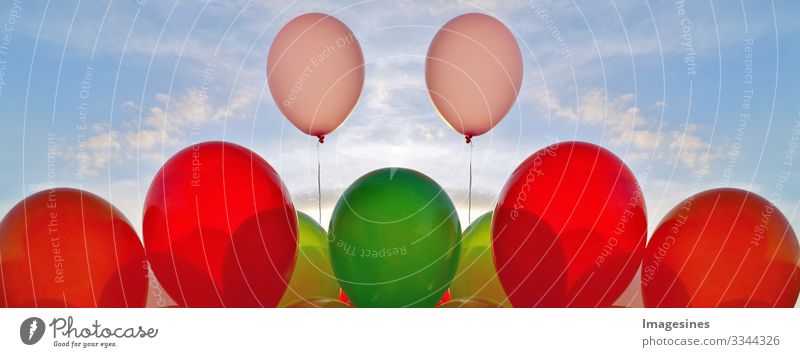 Balloons background and sun of the blue sky shining through clouds. decorative balloons in the blue sky. concept of love and Valentine's Day, wedding. outdoor party decoration