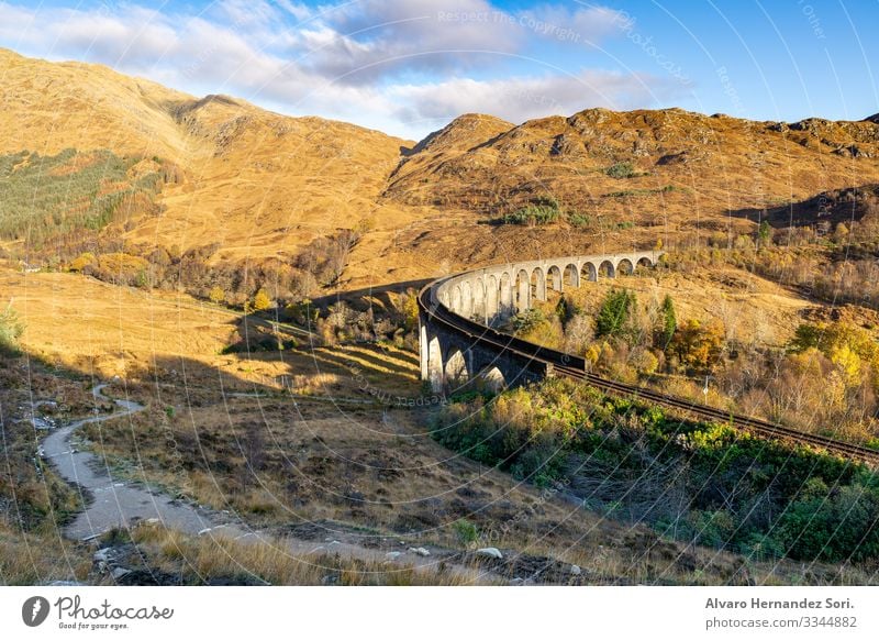 Glenfinnan Viaduct Nature Landscape Sky Clouds Sunlight Summer Autumn Beautiful weather Warmth Meadow Peak Deserted Train station Bridge Tourist Attraction