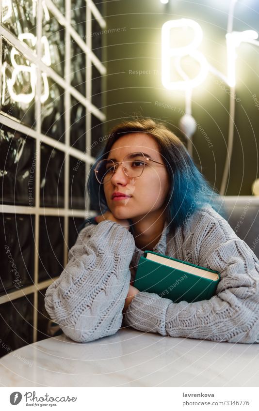 Female with blue hair holding a book in a cafe Adults Beauty Photography Book Café colorful hair Cute Education Face Woman Young woman Hold Interior shot