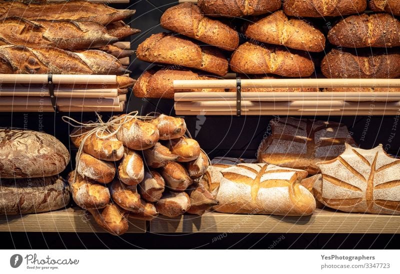 Bread assortment on bakery wooden shelves. Bread shop Food Dough Baked goods Roll Nutrition Shopping Healthy Eating Tradition Baguette Baker bakery interior