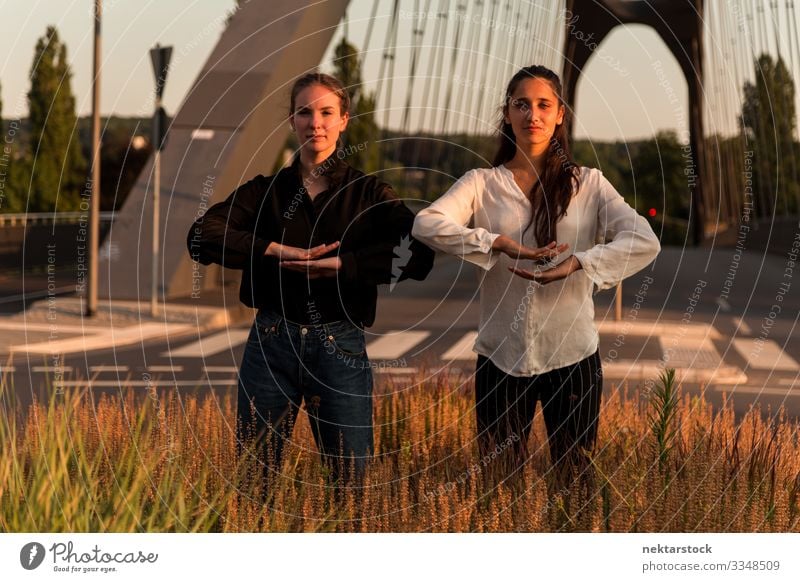 Two Women in Dance Poses on Roadside Grass Success Woman Adults Youth (Young adults) Contentment dancing girls pose hand sign Gesture dancers real life