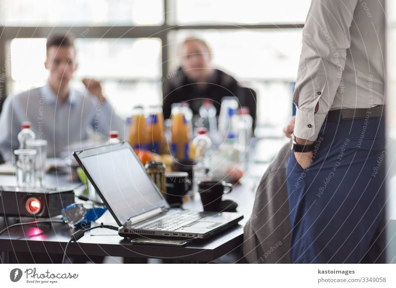 Business man making a presentation at office. Business executive delivering a presentation to his colleagues during meeting or in-house business training. Rear view. Business and entrepreneurship.